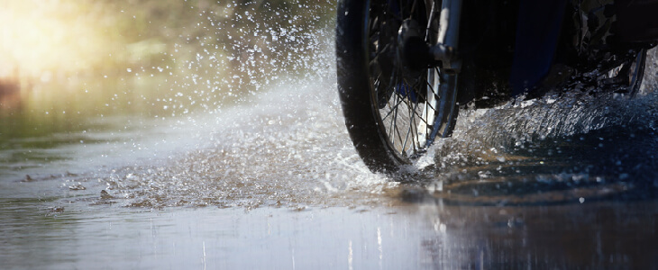 motorcycle riding through a puddle of water